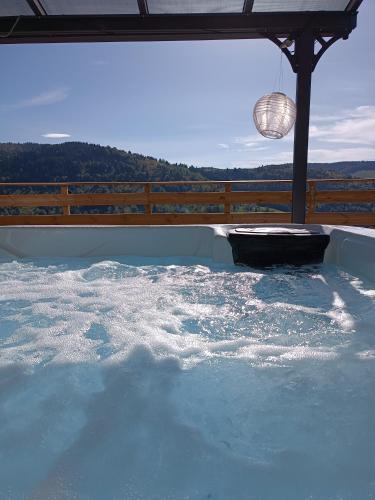un grand bassin d'eau avec une lumière au sommet dans l'établissement Les Chalets Bambi & Jacuzzi privatif, à La Bresse