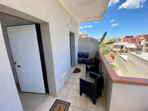 a balcony with a white door and some chairs at Secret Paradise & SPA Rooftop in Quartu SantʼElena
