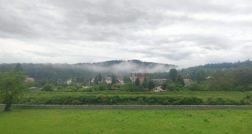 a town in the middle of a field with a mountain at Apartament Bella Zdrój in Głuchołazy