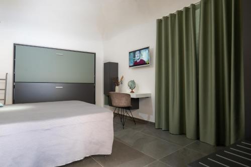 a bedroom with a bed and a desk and a screen at Il Castelluccio Scafati in Scafati