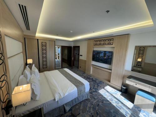 a hotel room with a large bed and a television at Mora Hotel in Al Khobar