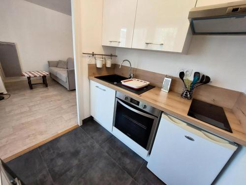 une cuisine avec des armoires blanches et un comptoir dans l'établissement Résidence Le Commodore - Agréable studio au coeur de la ville, quartier animé ! MAE-7864, à Aix-les-Bains