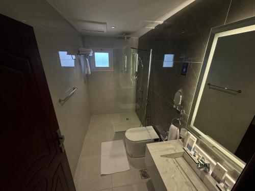 a bathroom with a toilet and a shower and a sink at Mora Hotel in Al Khobar