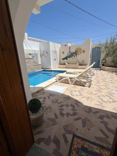 a view of a patio with a pool and a table at Dar KM in Erriadh