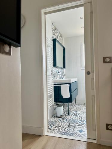 une salle de bain avec un lavabo bleu et un miroir dans l'établissement Villa Lavande, à Juvignac