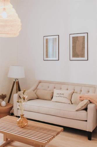 a living room with a white couch and a coffee table at Auberge du Plateau in Montréal