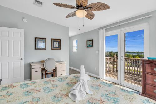 a bedroom with a bed with a ceiling fan at Blue Breeze in Duck Key
