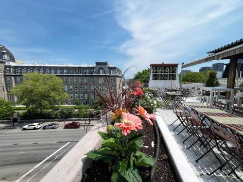 a balcony with chairs and flowers on a building at Auberge du Plateau in Montréal