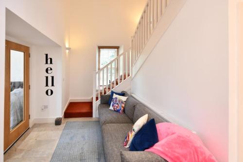 a living room with a couch and a staircase at 20 The Courtyard, Ballochmyle House in Mauchline