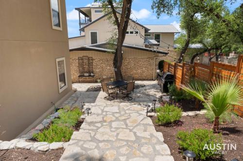a backyard with a stone walkway in front of a house at Lakeway Hideaway Cool Spot by The Colorado River in Austin