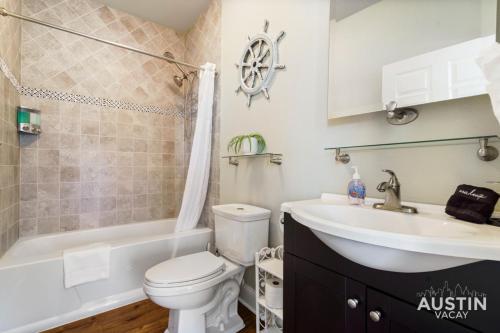 a bathroom with a toilet and a sink and a tub at Lakeway Hideaway Cool Spot by The Colorado River in Austin