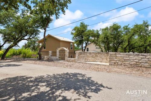 a house with a stone wall and a fence at Lakeway Hideaway Cool Spot by The Colorado River in Austin
