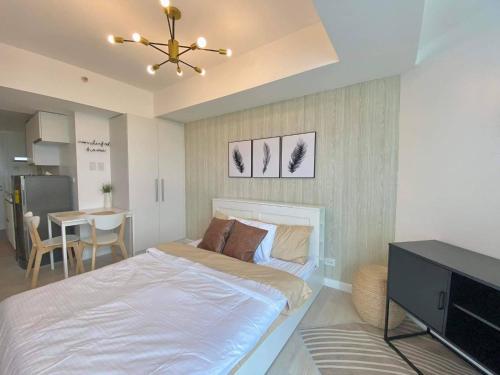 a bedroom with a bed and a dining room at Modern & Minimalist Space Azure North Residences in San Fernando