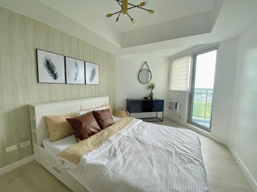 a bedroom with a bed and a ceiling fan at Modern & Minimalist Space Azure North Residences in San Fernando