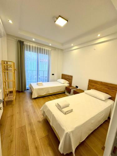 a hotel room with two beds and a window at Anfora Villaları in Belek