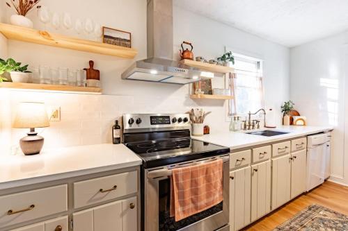 a kitchen with white cabinets and a stove top oven at The Green House - Central location PTC - Trilith in Tyrone