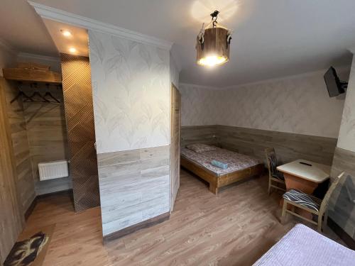 a room with a bed and a table and a lamp at uDany Noclegi ze Śniadaniem in Szczyrk