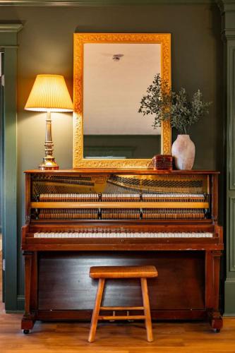 a piano in a room with a lamp and a mirror at The Green House - Central location PTC - Trilith in Tyrone