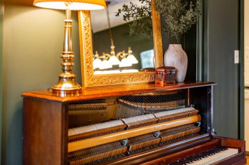 an old piano with a mirror and a lamp on it at The Green House - Central location PTC - Trilith in Tyrone