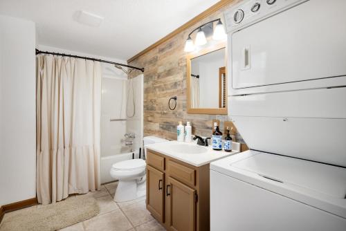 une salle de bain avec un lavabo blanc et des toilettes dans l'établissement Chalet w Hot Tub Deck Fire Pit Wifi Resort Fun, à Hedgesville