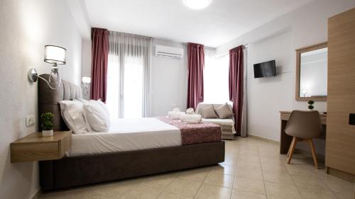 a bedroom with a bed and a desk and a couch at Evilion in Asprovalta