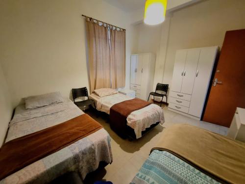 Un dormitorio con dos camas y una cómoda. en Cool Living Hostel - Praça da Liberdade, en Belo Horizonte