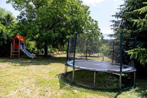 a trampoline in a park with a playground at Park Apartman in Sarród