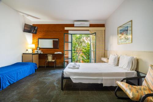 um quarto de hotel com uma cama e uma TV em Grinbergs Village Hotel em Socorro