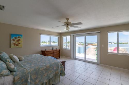 a bedroom with a bed and a ceiling fan at Manatee Bay in Key Colony Beach