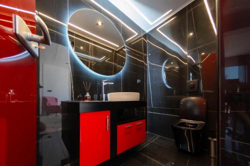 a bathroom with a sink and a red cabinet at Vip penthouse patra in Patra