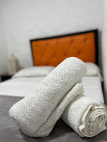 a pile of white towels sitting on a bed at HOTEl LAS FLORES in Santa Rosa de Cabal
