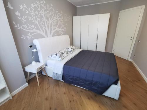 a bedroom with a bed and a tree mural on the wall at Lake&Stars - Il lago e le stelle in Ispra