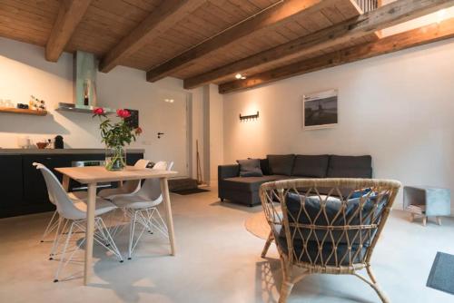 a living room with a couch and a table and chairs at Beautiful House in The Middle of Nature in Abcoude