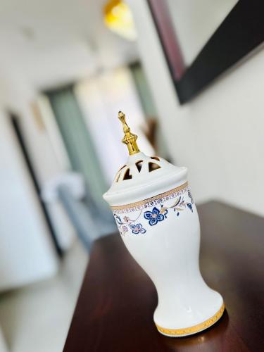 a white vase with a gold top on a table at villa by mount in Ratmalana
