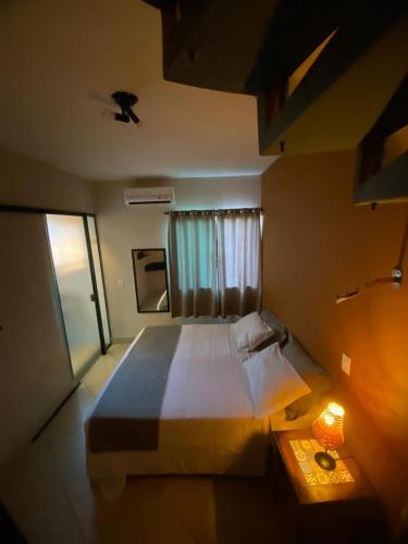a bedroom with a large bed and a window at Pousada Sol e Cia Tur in Caraguatatuba