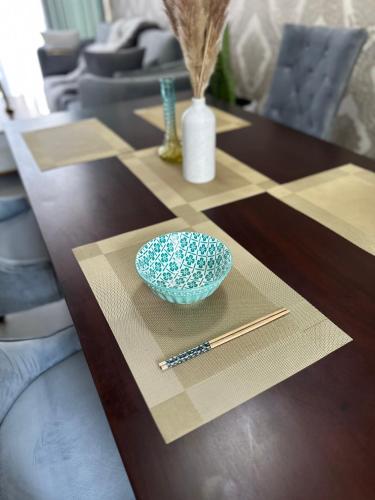 a wooden table with a bowl and chopsticks on it at villa by mount in Ratmalana