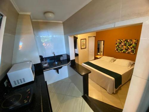 a hotel room with a bed and a sink at Pousada Sol e Cia Tur in Caraguatatuba