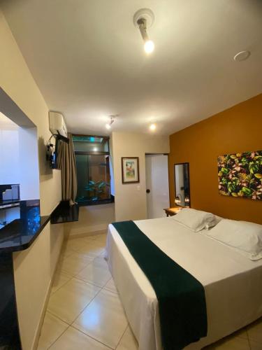 a bedroom with a large bed in a room at Pousada Sol e Cia Tur in Caraguatatuba