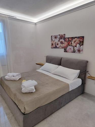 a bedroom with a large bed with towels on it at RIZZO RELAX Residence SALENTO in Capilungo