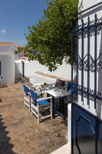 a table and chairs sitting next to a fence at Captain Hook in Hydra