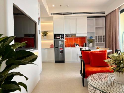 une cuisine avec une chaise orange et une table dans l'établissement Le Ciel Phu Quoc - Hillside Apartment, à Duong Dong