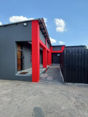 a black and red building with red columns at The Irenic Massage Spa and bnb in Hebron