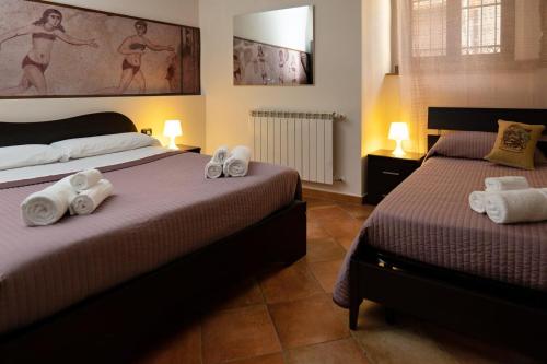 a bedroom with two beds with towels on them at B&B L'angolo di Plutia in Piazza Armerina