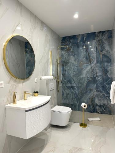 a bathroom with a sink and a toilet and a mirror at Villa Apartment Danny in Baška Voda