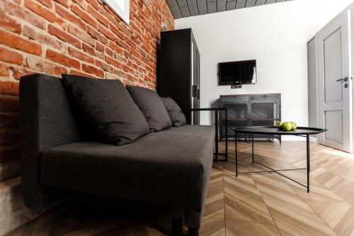 a living room with a couch and a brick wall at Old brick boutique apartments in Klaipėda