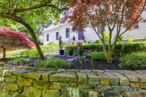 a stone retaining wall in front of a house at Mystic Retreat with Patio and Grill Walk to River! in Mystic