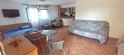 a living room with a couch and a table at Olgas Villa in Aroyí