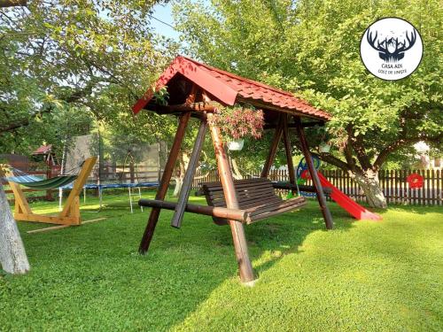 a playground with a bench and a gazebo at Casa Adi in Moieciu de Sus