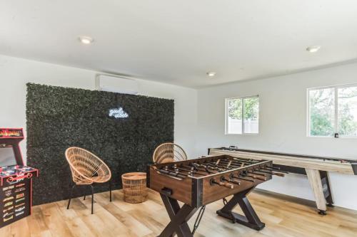 a room with a ping pong table and chairs at Modern Log Cabin at the beach with Hot Tub, Game Room and Fire Pit in Del Haven