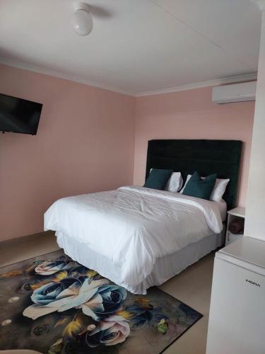 a bedroom with a white bed and a rug at The Irenic Massage Spa and bnb in Hebron